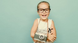 child holding a instant camera